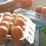 0_Hand-Pick-chicken-egg-from-egg-carton-box-into-refrigerator-eggs-on-shelf-of-cold-storage.jpg