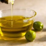 0_Olive-oil-pouring-into-small-glass-bowl-with-olives-on-table.jpg