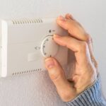 0_Woman-controlling-house-temperature-with-thermostat.jpg
