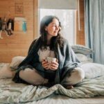 0_Woman-relaxing-in-bed-with-hot-drink-enjoying-cozy-cabin-atmosphere.jpg