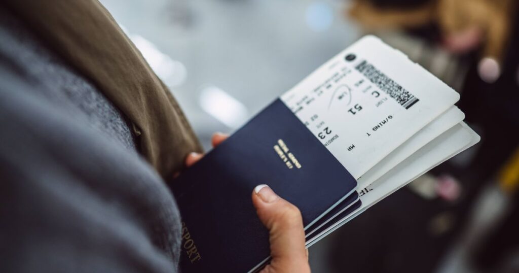 0_Womans-hands-holding-passports-boarding-passes-of-her-family-while-waiting-at-the-check-in-counter.jpeg