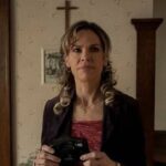 0_a-woman-stands-in-the-hallway-of-a-religious-home-and-holds-a-camera.jpg