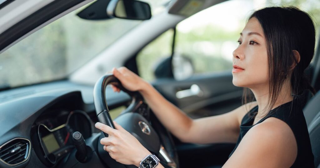 1_Side-view-of-young-Asian-woman-driving-a-car.jpg