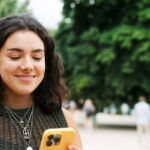1_Woman-using-smart-phone-on-tree-lined-promenade.jpg
