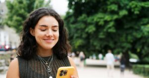 1_Woman-using-smart-phone-on-tree-lined-promenade.jpg