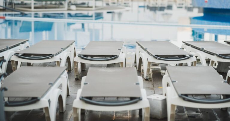 5_Empty-sunbeds-waiting-by-the-reflecting-water-of-a-swimming-pool-in-a-resort.jpg