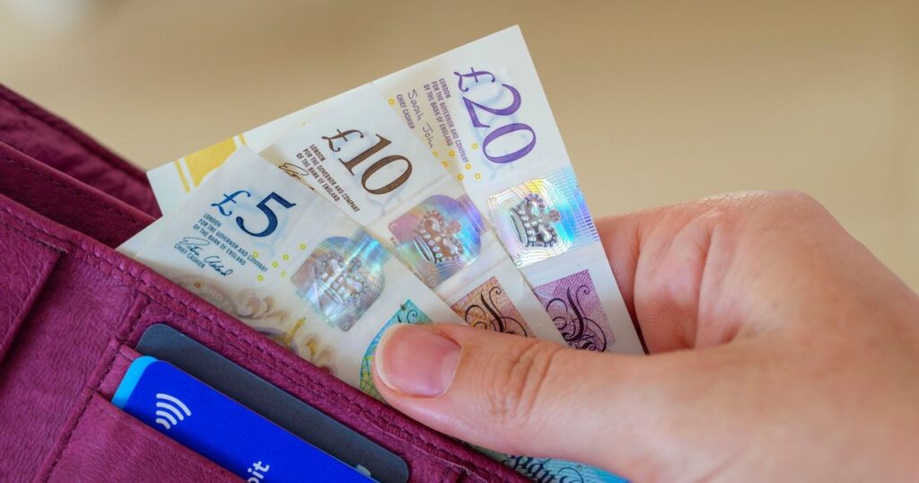 5_Taking-out-UK-pound-notes-in-cash-out-of-purse.jpg