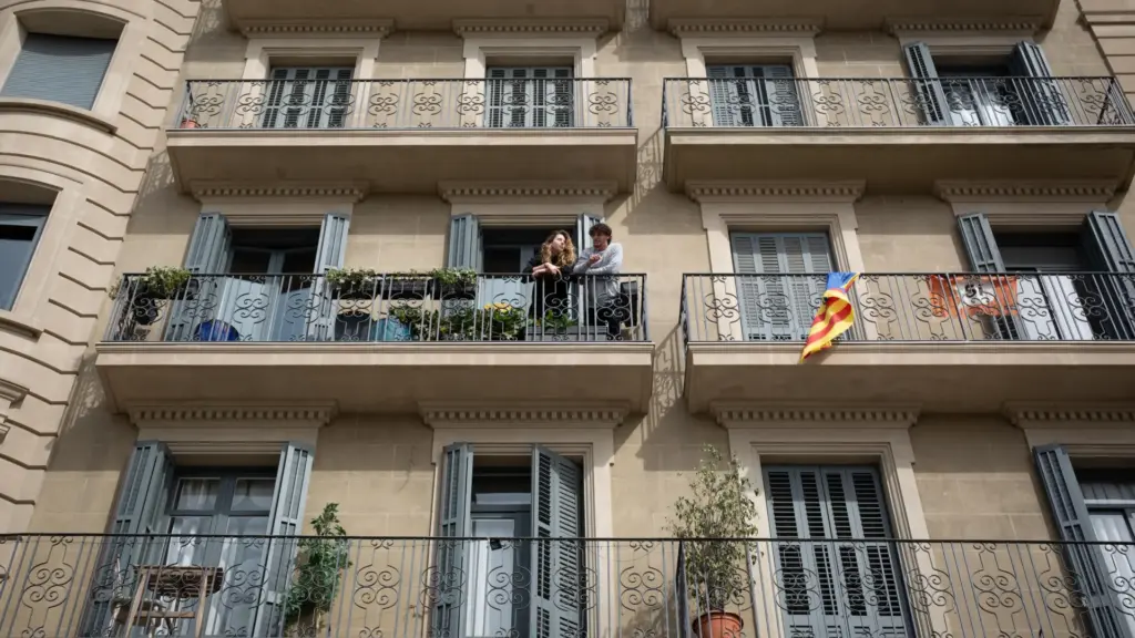 dos-personas-se-asoman-al-balcon-durante-el-estado-de-alarma-por-coronavirus-decretado-en-espana-dur.webp