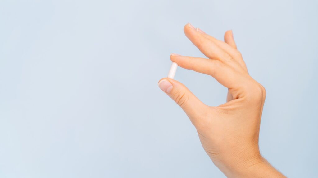 female-hand-holding-white-pill-1045015661.jpg