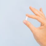 female-hand-holding-white-pill-1045015661.jpg