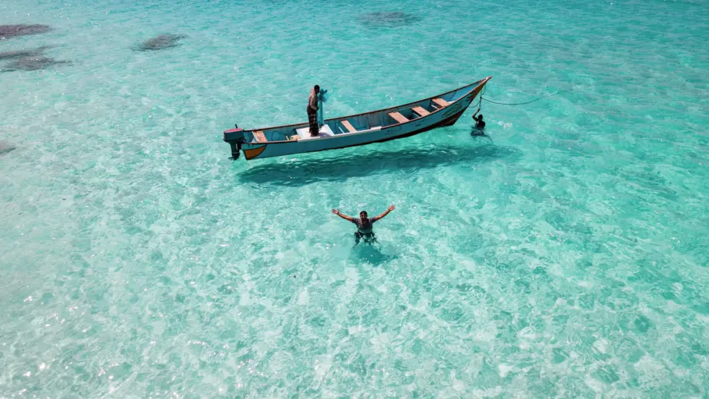 vista-aerea-de-pescadores-en-el-agua-junto-a-una-embarcacion-frente-a-la-playa-de-shoab-en-la-isla-y.webp
