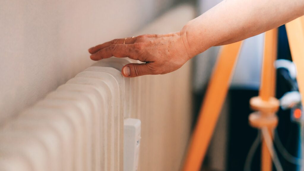 woman-checking-heating-radiator-cold-1051671144.jpg