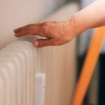 woman-checking-heating-radiator-cold-1051671144.jpg