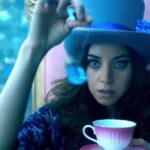 0_A-woman-in-a-purple-top-hat-holds-a-teacup-and-saucer.jpg