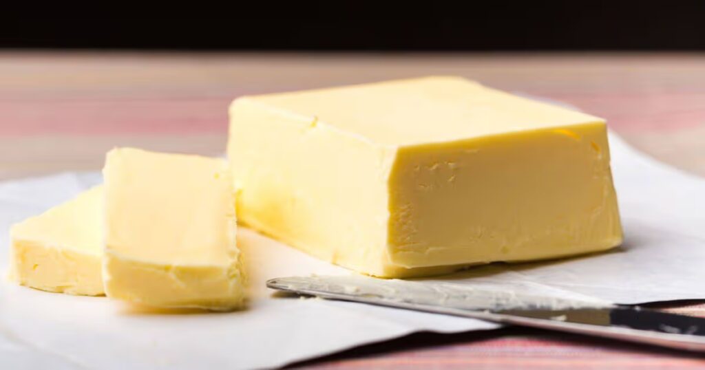 0_Close-up-of-a-block-of-butter-and-sliced-pieces-on-parchment-paper-with-a-knife-ready-for-use.jpg