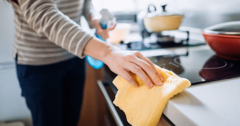 0_Cropped-shot-of-a-young-woman-cleaning-the-kitchen-counter-with-cleaning-spray-and-cloth-at-home-d.avif