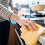 0_Cropped-shot-of-a-young-woman-cleaning-the-kitchen-counter-with-cleaning-spray-and-cloth-at-home-d.avif