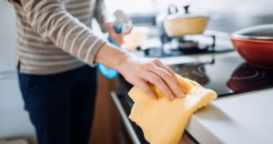0_Cropped-shot-of-a-young-woman-cleaning-the-kitchen-counter-with-cleaning-spray-and-cloth-at-home-d.avif