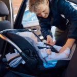 0_Father-putting-baby-in-safety-car-seat-happy-family-vacation-road-trip-lifestyle-child-care-transp.avif