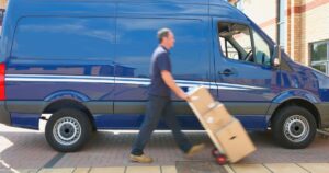 2_Blurred-view-of-Caucasian-delivery-man-wheeling-packages.jpg