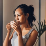 3_A-beautiful-young-Hispanic-woman-enjoying-a-warm-cup-of-coffee-for-breakfast-One-mixed-race-female.avif