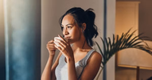 3_A-beautiful-young-Hispanic-woman-enjoying-a-warm-cup-of-coffee-for-breakfast-One-mixed-race-female.avif
