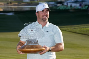 Chris-Gotterup-smiles-as-he-holds-up-the-winners-trophy-after-defeating-Hideki-Matsuyama-in-a-one-ho.avif